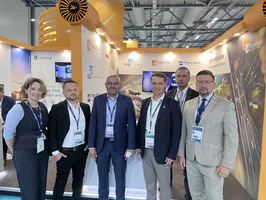 Sześć osób pozuje do wspólnego zdjęcia na stoisku promującym Rzeszów i potencjał inwestycyjny Podkarpacia podczas Farnborough International Airshow 2026.
