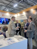 Cztery osoby prowadzą rozmowę biznesową przy stoisku promującym Rzeszów i region Podkarpacia podczas Farnborough International Airshow 2026.