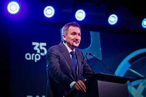 Osoba w garniturze przemawia z mównicy na scenie podczas wydarzenia jubileuszowego; w tle widoczny napis „35 lat arp” oraz sceniczne oświetlenie w odcieniach niebieskiego.