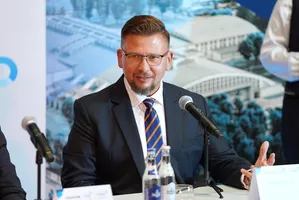 Wiktor Cichoń, Dyrektor SSE EURO-PARK MIELEC, przemawia przy stole konferencyjnym, gestykulując dłonią przed mikrofonem.