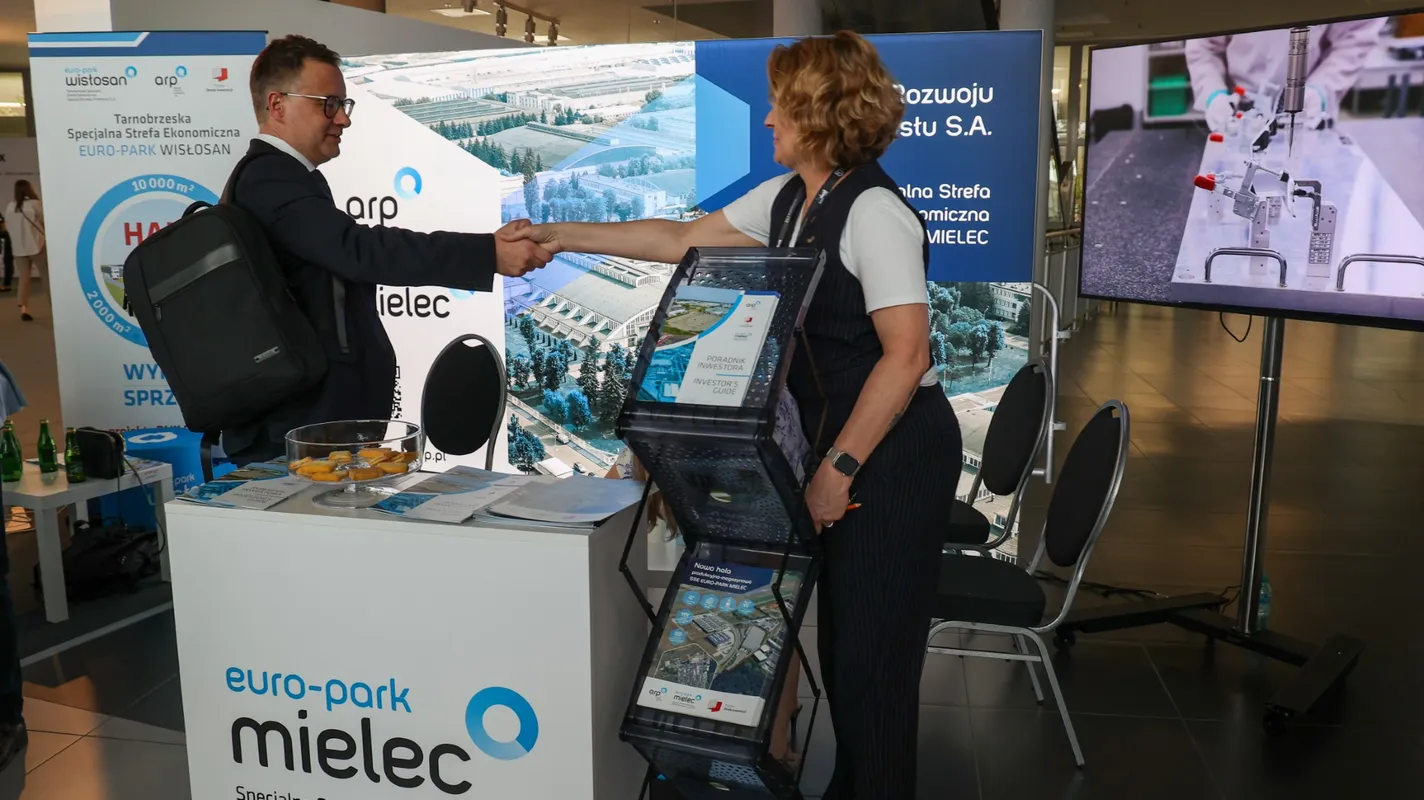 Uczestnicy Kongresu Bezpieczeństwo Polski 2026 wymieniają uścisk dłoni przy stoisku Specjalnej Strefy Ekonomicznej EURO-PARK MIELEC w strefie wystawienniczej ZEN.COM Expo