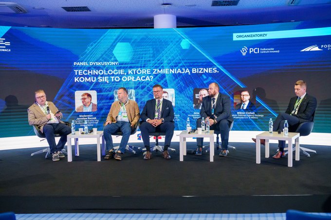 Pięciu uczestników panelu „Technologie, które zmieniają biznes. Komu się to opłaca?” podczas PFNI 2026, z udziałem przedstawiciela ARP S.A., siedzi na scenie na tle ekranu z tytułem dyskusji.