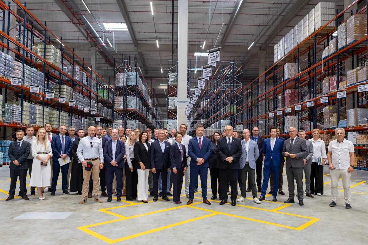 Grupa uczestników stojąca w hali magazynowej podczas uroczystego otwarcia Centrum Dystrybucyjno-Logistycznego Jeronimo Martins Polska S.A. w Sokołowie Małopolskim